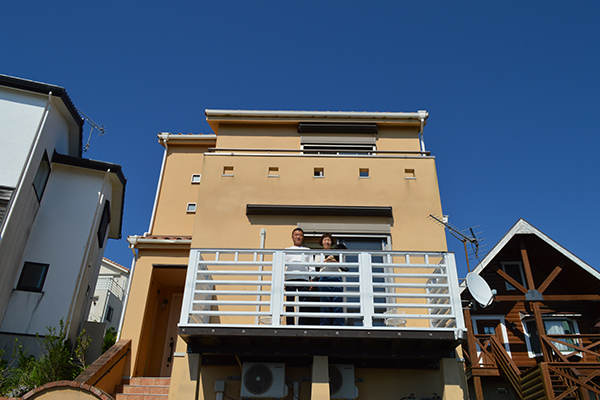 アースカラーの外壁に映える白い手すり